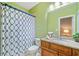 Bathroom featuring granite countertops, wood cabinets, and green painted walls at 10731 Bossier Dr, Alpharetta, GA 30022