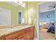 Granite vanity with double sinks inside a colorful bathroom, adjacent to a blue themed bedroom at 10731 Bossier Dr, Alpharetta, GA 30022