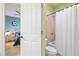 Bathroom with a white shower curtain, toilet, and doorway leading to a bedroom at 10731 Bossier Dr, Alpharetta, GA 30022