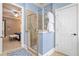 Bathroom with a glass enclosed shower, tile surround, and a view into an adjacent bedroom at 10731 Bossier Dr, Alpharetta, GA 30022