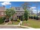 Charming brick home featuring a well-manicured front yard with lush greenery and a welcoming walkway at 10731 Bossier Dr, Alpharetta, GA 30022