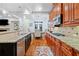 Open kitchen with granite counters, wood floors, and stainless steel appliances at 10731 Bossier Dr, Alpharetta, GA 30022