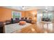 Living room with wood floors, orange accent wall, and view to an office at 10731 Bossier Dr, Alpharetta, GA 30022