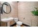 Stylish half bathroom features modern fixtures, a decorative mirror, and wood flooring at 10731 Bossier Dr, Alpharetta, GA 30022