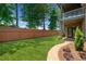 Well-maintained backyard featuring a lush lawn, privacy fence, patio, and landscaped garden bed at 10731 Bossier Dr, Johns Creek, GA 30022
