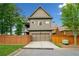 Exterior home view featuring a two-car garage, fenced yard, and well-maintained landscaping at 10731 Bossier Dr, Johns Creek, GA 30022