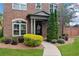 Close up of a brick house with a landscaped yard, tidy shrubs and a wreath on the front door at 10731 Bossier Dr, Johns Creek, GA 30022