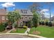 Charming brick home featuring a well-manicured lawn, mature trees, and an inviting entrance, enhancing curb appeal at 10731 Bossier Dr, Johns Creek, GA 30022