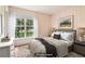 A virtually staged bedroom with a large window, comfortable bed, coordinated furnishings and neutral tones at 885 Falling Water Ln, Norcross, GA 30093