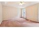Empty bedroom featuring wallpapered walls, carpeted flooring, and bright, natural light from the window at 885 Falling Water Ln, Norcross, GA 30093