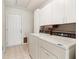 Well-lit laundry room featuring matching washer and dryer set, white cabinets, and a practical layout at 885 Falling Water Ln, Norcross, GA 30093