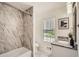 Updated bathroom featuring elegant marble tile shower and floors and a stylish granite vanity at 3290 Spincaster Way, Loganville, GA 30052