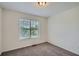 Minimalist bedroom with a large window, neutral carpet, and bright lighting at 3290 Spincaster Way, Loganville, GA 30052
