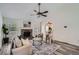 Bright living room features a stone fireplace, modern ceiling fan, and cozy seating area at 3290 Spincaster Way, Loganville, GA 30052