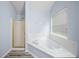 A bathtub with a window is beside a standing shower at 5380 Rock Place Drive, Stone Mountain, GA 30087