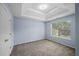 This carpeted bedroom features a trey ceiling, blue walls, and a large window for natural light at 5380 Rock Place Drive, Stone Mountain, GA 30087
