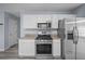 Bright kitchen features white cabinets, stainless steel appliances, and stone countertops at 5380 Rock Place Drive, Stone Mountain, GA 30087