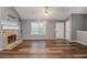 Bright living room with a cozy stone fireplace, window views, and hardwood floors at 6797 Braswell Mountain Rd, Rockmart, GA 30153
