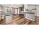 Spacious living room featuring wood floors, bright windows, and a partial view of the kitchen at 6797 Braswell Mountain Rd, Rockmart, GA 30153
