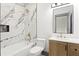 This bathroom features marble tile surround, a tub, and a modern vanity at 2369 Mcafee Rd, Decatur, GA 30032