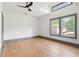 This bedroom features gray trim, hardwood floors, a ceiling fan, and many windows at 2369 Mcafee Rd, Decatur, GA 30032