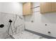The laundry room features marble tile floors and walls and custom cabinets for storage at 2369 Mcafee Rd, Decatur, GA 30032