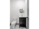 Modern powder room with black vanity, gold fixtures, marble floors, and a round mirror at 2369 Mcafee Rd, Decatur, GA 30032