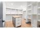 This walk-in closet boasts custom shelving, a wood floor, and an island with storage at 2369 Mcafee Rd, Decatur, GA 30032
