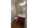 Convenient half bathroom featuring hardwood floors, a vanity with sink, and a toilet at 5190 Southlake Dr, Alpharetta, GA 30005