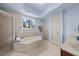 Bright bathroom features an attractive soaking tub with jets near a window at 1376 Parkview Ne Ln, Atlanta, GA 30324