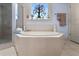 Bathroom features soaking tub surrounded by tile, with a window and separate shower at 1376 Parkview Ne Ln, Atlanta, GA 30324