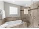 Modern bathroom with a glass enclosed shower, soaking tub, and neutral tile at 176 Rockyford Ne Rd, Atlanta, GA 30317