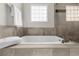 Bathroom featuring a luxurious soaking tub with tile surround and modern fixtures at 176 Rockyford Ne Rd, Atlanta, GA 30317