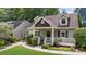 Inviting craftsman home showcases a cozy front porch and lush front yard with shrubbery at 176 Rockyford Ne Rd, Atlanta, GA 30317