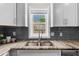 Close up of the kitchen sink featuring modern fixtures and tile backsplash at 176 Rockyford Ne Rd, Atlanta, GA 30317