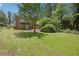 Spacious backyard with a well-maintained lawn, mature trees and partial home view at 3611 Radcliffe Blvd, Decatur, GA 30034