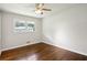 This bedroom features hardwood floors, a ceiling fan, and a window overlooking the yard at 3611 Radcliffe Blvd, Decatur, GA 30034
