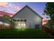 Back of home at dusk features a covered patio and a spacious, grassy backyard at 587 Woods Nw Dr, Atlanta, GA 30318
