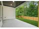 Back porch leads to the backyard that has a new wooden fence and grass at 587 Woods Nw Dr, Atlanta, GA 30318