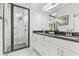Modern bathroom with tiled shower, glass doors, double sinks, and granite countertops at 587 Woods Nw Dr, Atlanta, GA 30318