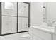 Modern bathroom with a tiled shower, black frame, and a white vanity at 587 Woods Nw Dr, Atlanta, GA 30318