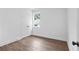 A bright bedroom with hardwood floors, a large window, and a closet with double doors at 587 Woods Nw Dr, Atlanta, GA 30318