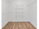 Walk-in closet with hardwood floor and wire shelving to keep clothes organized at 587 Woods Nw Dr, Atlanta, GA 30318