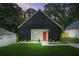 Charming exterior elevation of a modern home with black siding, a bright orange front door and a well manicured lawn at 587 Woods Nw Dr, Atlanta, GA 30318