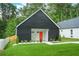 Charming modern home featuring a black exterior, orange front door, and a lush green lawn at 587 Woods Nw Dr, Atlanta, GA 30318