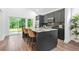 Modern kitchen with dark cabinets, granite countertops, stainless steel appliances, and view to the backyard at 587 Woods Nw Dr, Atlanta, GA 30318