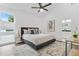 Spacious main bedroom boasts large window, ceiling fan, stylish carpet, and doorway to the bathroom at 587 Woods Nw Dr, Atlanta, GA 30318