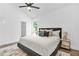 Bright main bedroom features a large window, ceiling fan, comfortable decor, and doorway to the closet at 587 Woods Nw Dr, Atlanta, GA 30318