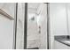 Bathroom shower with marble tile, bench, shower head, and sleek glass doors at 587 Woods Nw Dr, Atlanta, GA 30318