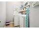 Bright laundry area with white washer and dryer, storage shelves, and a small window at 2755 Evan Manor Ln, Cumming, GA 30041